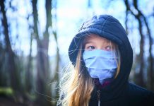 Une jeune femme à l'air déprimé sous son masque, en plein hiver, au moment du blue monday.