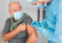 Un homme âgé reçoit la double vaccination grippe et covid-19.