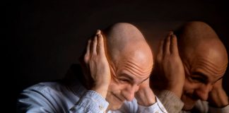 Un homme atteint par la schizophrénie se bouche les oreilles